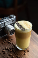 Traditional russian raff coffee with spices on a vintage background with wooden table and retro camera