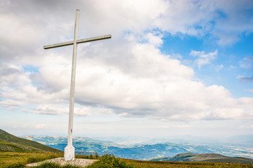 Obraz premium White cross on meadow in green mountainsnear Travnik city in Bosnia and Herzegovina