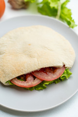 Wheat pita with green lettuce, chicken and tomatoes as a perfect snack for lunch in coffee house