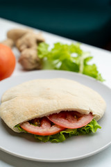 Wheat pita with green lettuce, chicken and tomatoes as a perfect snack for lunch in coffee house