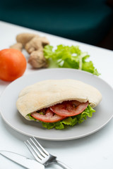 Wheat pita with green lettuce, chicken and tomatoes as a perfect snack for lunch in coffee house