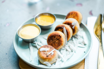 Vegan tofu cheese pancakes on blue plate, gray concrete table. Sun light. Food blog photography concept