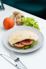 Wheat pita with green lettuce, chicken and tomatoes as a perfect snack for lunch in coffee house