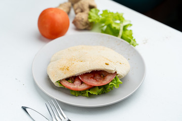 Wheat pita with green lettuce, chicken and tomatoes as a perfect snack for lunch in coffee house
