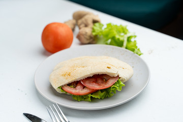 Wheat pita with green lettuce, chicken and tomatoes as a perfect snack for lunch in coffee house