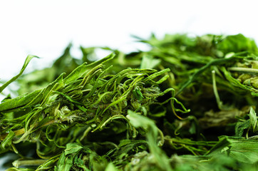 Macro photo of a large pile of buds and marijuana leaves