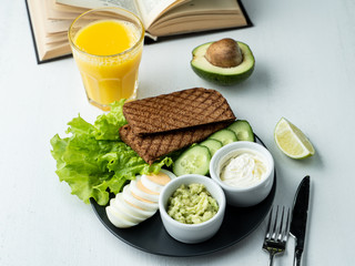 Crunchy rye toasts with fresh lettuce, hard boiled eggs, cream cheese, guacamole and cucumber with fresh pulpy orange juice - a perfect combo for slow breakfast