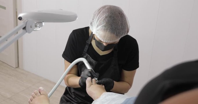 Hardware pedicure process video. Professional manicurist removes keratinized skin with nail drill