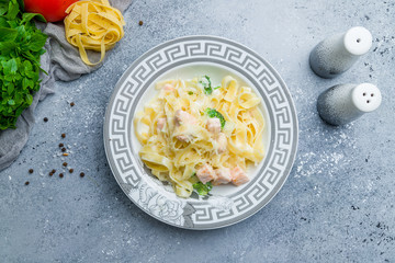 fettuccine with salmon and broccoli on beautiful grey table
