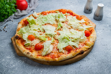Pizza Caesar on board on beautiful grey table