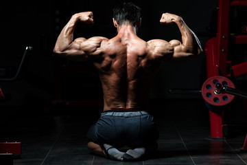 Fototapeta na wymiar Muscular Man Flexing Muscles Rear Double Biceps Pose