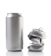 Closeup of a full aluminum can and one crushed empty can. Cans have no label.