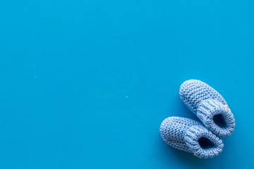 Cute baby booties for boy on blue background top view copyspace