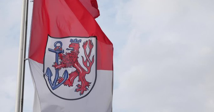 Flag of the city of D&uuml;sseldorf in the state of North Rhine-Westphalia, Germany waving in wind and background of cloudy sky.
