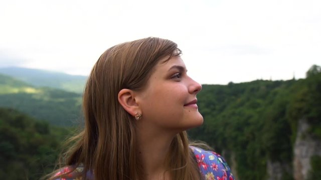 Young Woman laughs. Tourist Travel Vacation. Traveling mountains, freedom and active lifestyle concept. Young girl traveler at cityscape beautiful view background in Okatse canyon, Georgia. Slow mo