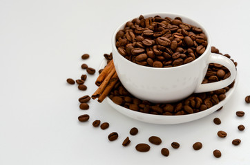 Coffee cup with roasted coffee beans on white.