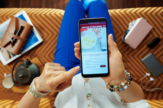 modern housewife subscribing to internet tv on smartphone