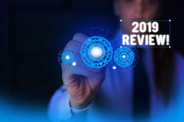 Text sign showing 2019 Review. Business photo showcasing remembering past year events main actions or good shows Woman wear formal work suit presenting presentation using smart device