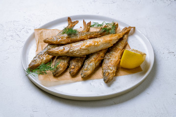 fried surmullet on white plate on white concrete table