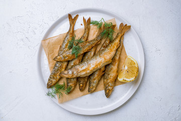 fried surmullet on white plate on white concrete table