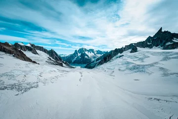 Fotobehang Gletsjer Beautiful wide shot of ruth glaciers covered in snow under a blue sky with white clouds  © Francesco Ungaro/Wirestock