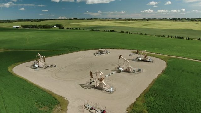 Aerial Drone Shot of Alberta Oil Pump Jacks on a Clear Summer Day in the Prairies, Calgary Alberta Canada. Oil and Gas Facility