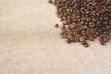 high angle view of a heap of a fresh rosted coffee beans on a burlap sack. concept of favorite drink