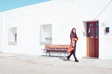 young woman with trench coat walking and rolling up her sleeves