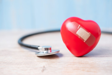 Stethoscope with Red heart shape on wooden background. Healthcare, life Insurance and World Heart Day concept