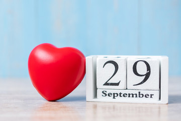 September 29 of white calendar and Red heart shape on wooden background. Healthcare, life Insurance and World Heart Day concept