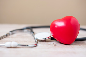 Stethoscope with Red heart shape on wooden background. Healthcare, life Insurance and World Heart Day concept