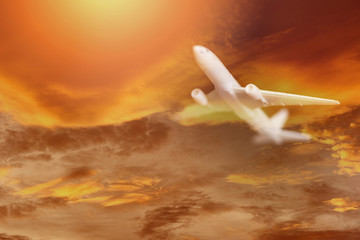 Airplane storm flying in the orange sky with clouds at colorful sunset Travel background - Traveler's Airlines plane  dramatic sky and lightning flying at bad weather with red clouds