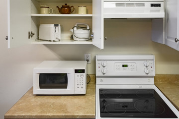 Obraz premium Open cabinets and primary appliances on average home kitchen.