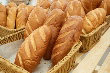a lot of fresh bread in a basket for sale in a supermarket