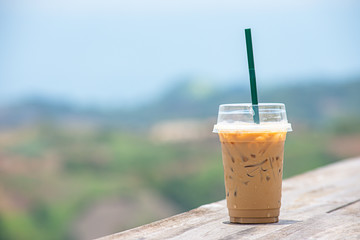 Glass of cold espresso coffee on the table Background blurry views tree and Mountain.