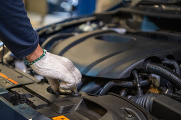 Closeup hand of auto mechanic examine car engine breakdown problem in front of automotive vehicle car hood. Safety technical inspection care check service maintenance for customer before road trip