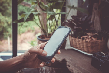 Woman hand using smartphone in cafe shop blur beautiful background. Business, financial, trade stock maket and social network concept.