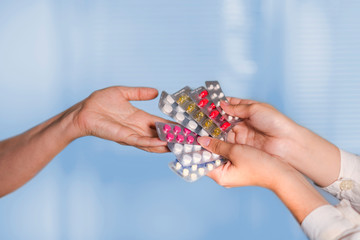 Doctor holds out a fan of pills to the patient