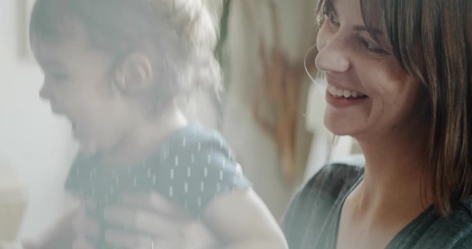 Mother playing with daughter at home on the couch. Real life, candid footage. Shot in 4K RAW on a cinema camera.