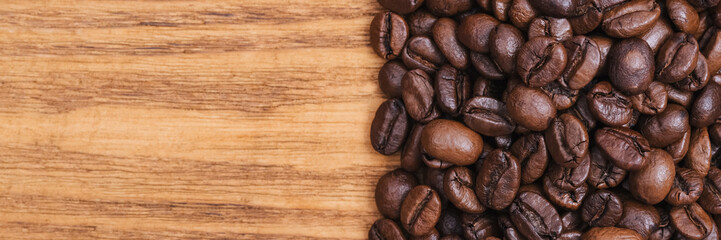 Coffee bean. The background of roasted coffee beans is brown on wooden boards. layout. Flat lay.