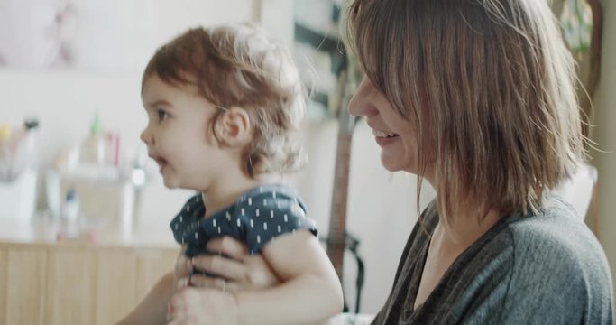 Mother playing with daughter at home on the couch. Real life, candid footage. Shot in 4K RAW on a cinema camera.