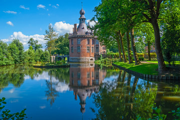 Reflection of the Ooidonk castle on a summer day located in the Leie river region near Gent (Ghent...