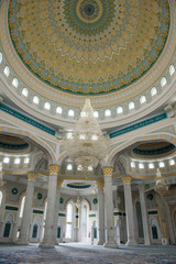 Fototapeta na wymiar Hazret Sultan Mosque in the city of Nur Sultan. The interior of the mosque, dome and chandelier.