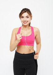 portrait of a smiling fitness woman in headphones working out isolated over white background