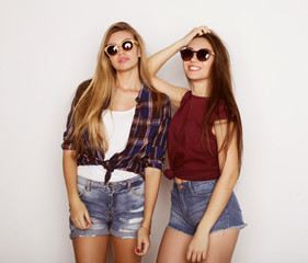 lifestyle, friendship and people concept: Two young girl friends standing together and having fun. Hipster style.