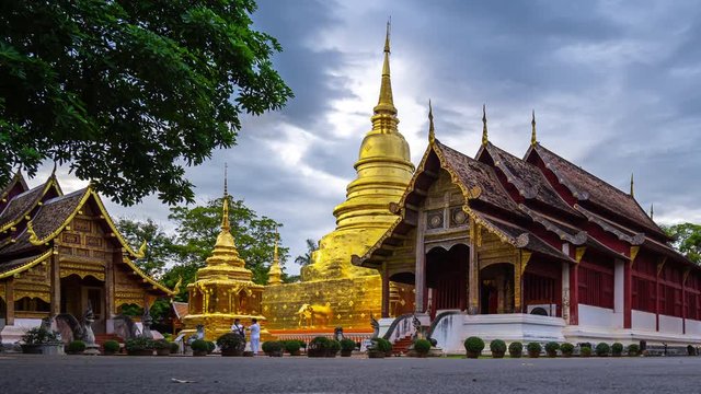 Zoom out shot of 4K Time lapse of Wat Phra Singh Temple in twilight time and reflection. Day to Night shot of beautiful traditional architecture  at Wat Phra Singh Temple Of Chiangmai Thailand.