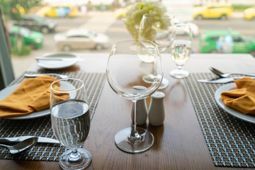 Fresh romantic breakfast table next to morning briliant light window with glasses prepare for the meal