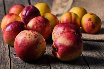 Ripe peaches with leaves on an old wooden table on a dark background. Soft selective focus