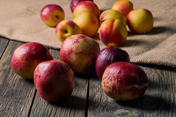 Ripe peaches with leaves on an old wooden table on a dark background. Soft selective focus