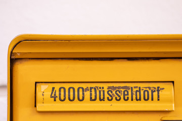 Gelber Briefkasten mit Aufschrift 4000 Düsseldorf lädt zur analogen Kommunikation per Brief und...